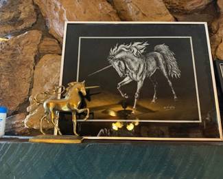 Framed unicorn and brass statue.