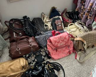 Dozens of Coach wallets and handbags, multiple new with tags attached 