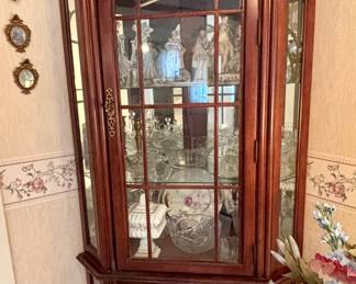 Corner curio cabinet, has a light