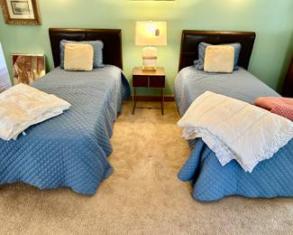 A pair of leather headboard twin beds