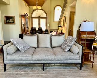 Sofa by Ferguson Copeland Ltd, upholstery is an oyster color with nailhead trim and a black wood frame.