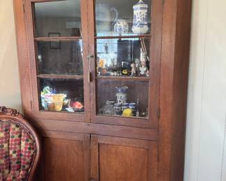 This is an early to mid 1800s stained pine corner hutch with two glass doors and two lower storage doors.