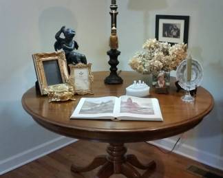 Round cherry pedestal table includes two leaves