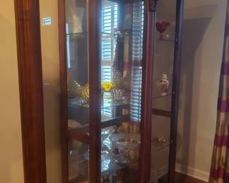 The front of the curio cabinet slides open