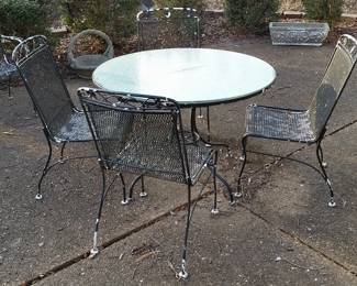 Patio table with round glass top and four chairs