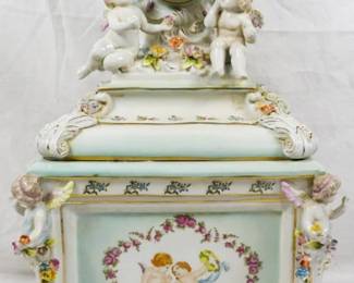 202 - Porcelain Lidded Box w/ Clock & Cherubs 18" You are buying a used as-is item. We do not guarantee all components are present, and if it is not expressly stated, it is untested.
