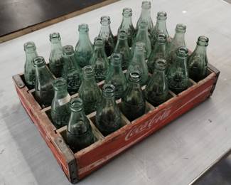 Vintage Coca-Cola glass bottles in labeled wooden crate
