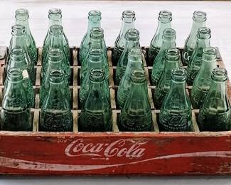Vintage Coca-Cola glass bottles in labeled wooden crate