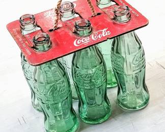 Vintage Coca-Cola glass bottles in tin antique holder