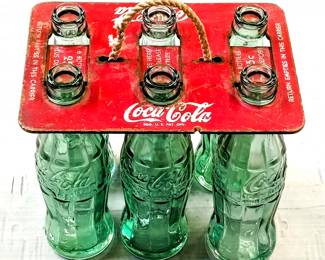 Vintage Coca-Cola glass bottles in tin antique holder