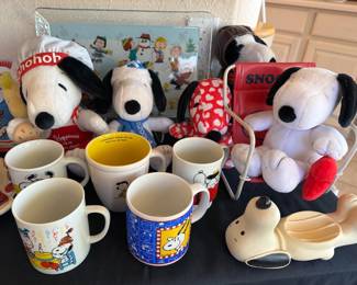 Assorted Snoopy items: stuffed animals, mugs, glass plate