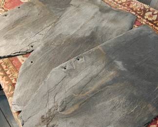 A stack of about 25 slate roofing tiles 