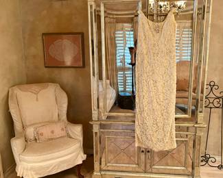Gorgeous mirrored armoire, vintage dress and pretty slip-covered chair