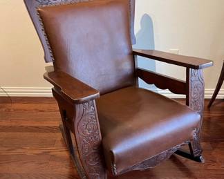 Antique rocker with carving and reupholstered with leather