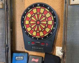 This is a fun item. It’s an electronic dartboard in its case that hangs on the wall, and the three boxes below the dartboard are all professional darts.!