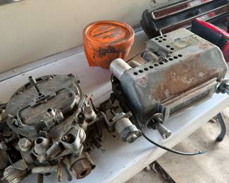 To left is an old carburetor, I am unsure what car goes to. And that the right is an old Chevy AM radio.
