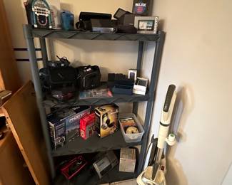 This shelving unit has lots of electronics and vintage cameras!