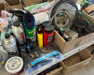 The back side of the table has lots of car, clean accessories, and the box to the right is filled with motorcycle parts