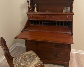 Eastlake-style (ca 1940) solid walnut slant front desk.  56” tall, 34” wide, 20” deep.  $400