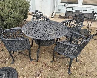 Vintage cast iron table with 4 chairs and umbrella stand.