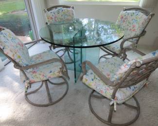 Leon Rosen round glass table and 4 swivel chairs with cushions.
