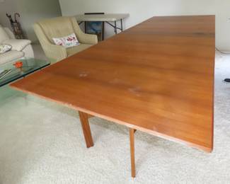 MCM when stowed away this Swedish teak dining table measures 8 inches deep but when extended it measures 9 ft long and 39 inches wide. It has 4 hinged leaves and legs that unfold revealing this great table.