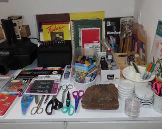 Art supplies, sketch books, tracing paper, brushes, acrylic paints, scissors, pastels.