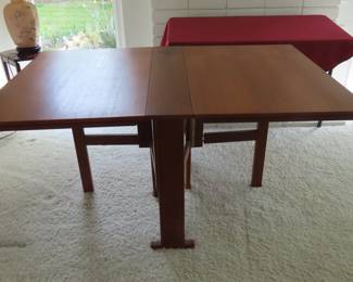 MCM when stowed away this Swedish teak dining table measures 8 inches deep but when extended it measures 9 ft long and 39 inches wide. It has 4 hinged leaves and legs that unfold revealing this great table.