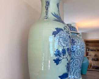 a Chinese blue/white porcelain vase with a celadon ground, likely from the 19th century. 
It features underglaze blue hand-painted decorations on a pale green celadon body. motifs phoenix and peonies, 23”h x 9.5” diameter aprox 20lbs