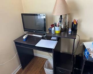 black office desk, computer monitor, miscellaneous office items, lamp