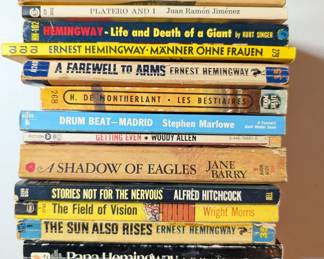 Paperback books by Ernest Hemingway, Peter Ustinov, Woody Allen, Alfred Hitchcock