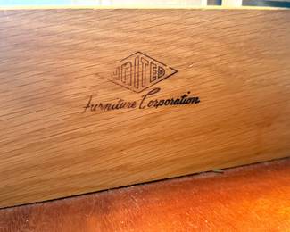 Closeup of brand markings on mid century long dresser with mirror by United Furniture Corporation