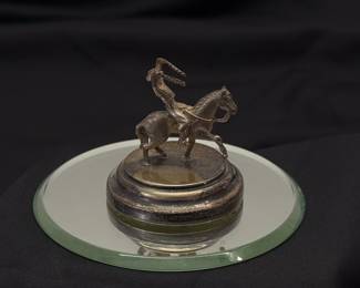 Small sculpture of cowboy on a horse, atop a mirrored base. Possibly silver plate, edition number on base