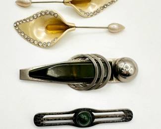 A pair of celluloid Calla lily stick pins with embedded rhinestones, an Art deco chrome and Bakelite brooch, and a Native American brooch 
