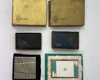 Two Mondaine leather book style powder and rouge compacts with original boxes, a silver toned mirror compact with pouch, and a gold fleur de lis white and aqua color compact in original box