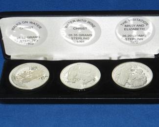 Lot 399. Three coin sterling silver religious-themed medallion set. Total weight 79.17 grams.