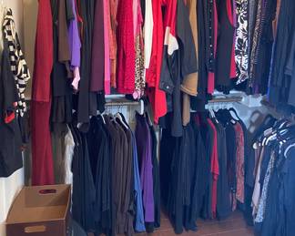 There are five large rods of clothes filled in the walk-in closet with beautiful ladies clothing
