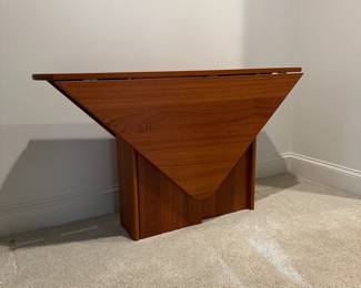 F94 - $950. Danish Teak Triangular Drop Leaf Table. Sides drop down making it narrow enough for a hallway or sofa table but opens large enough for 4 people. Measures 10" wide when folded down x 52" long. Each leaf comes up 22". So a 52" x 54" almost square!