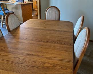 Oak dining table with 8 upholstered chairs. Pictured there is 1 leaf addition, and comes with one additional leaf! Great for entertaining!