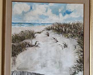 This framed painting shows a beach sand dune berm, although it looks like a windy day.