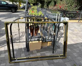 It is a bit tricky to see here, but there is a bedframe (gold-toned rectangle frame) and headboard (black with gold-toned accent and an arched top).