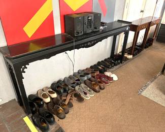 Underneath the table are a lot of shoes.  Come to the sale and see them all.
