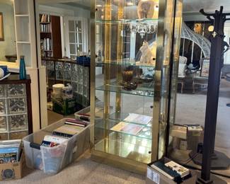 In this photo you can see the brass, lighted display case, and a coat and hat rack off to the right.