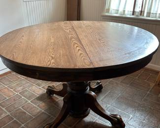 Circa 1910 quarter sewn oak round claw foot dining table with 2 leaves