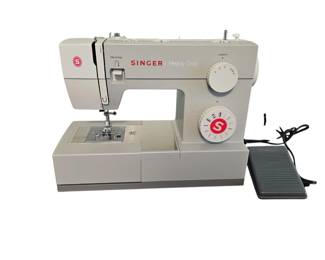 BRAND NEW SINGER SEWING MACHINE with booklet, and carrying case. Also have box. Has coupon for sewing lessons and percentage off notions.