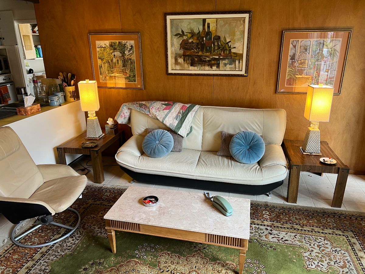 Italian MCM leather couch, vintage travertine coffee table, vintage end tables, fabulous table lamps, leather swivel chair, vintage Persian rug, MCM oil painting (center) & framed prints (flanking) vintage phone, round blue tufted pillows VINTAGE  - ALL AVAILABLE TO TAKE HOME THIS SATURDAY!