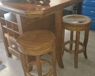 This center movable island/table grouping has four stools and two drawers, with cubbies on each side above the drawers.