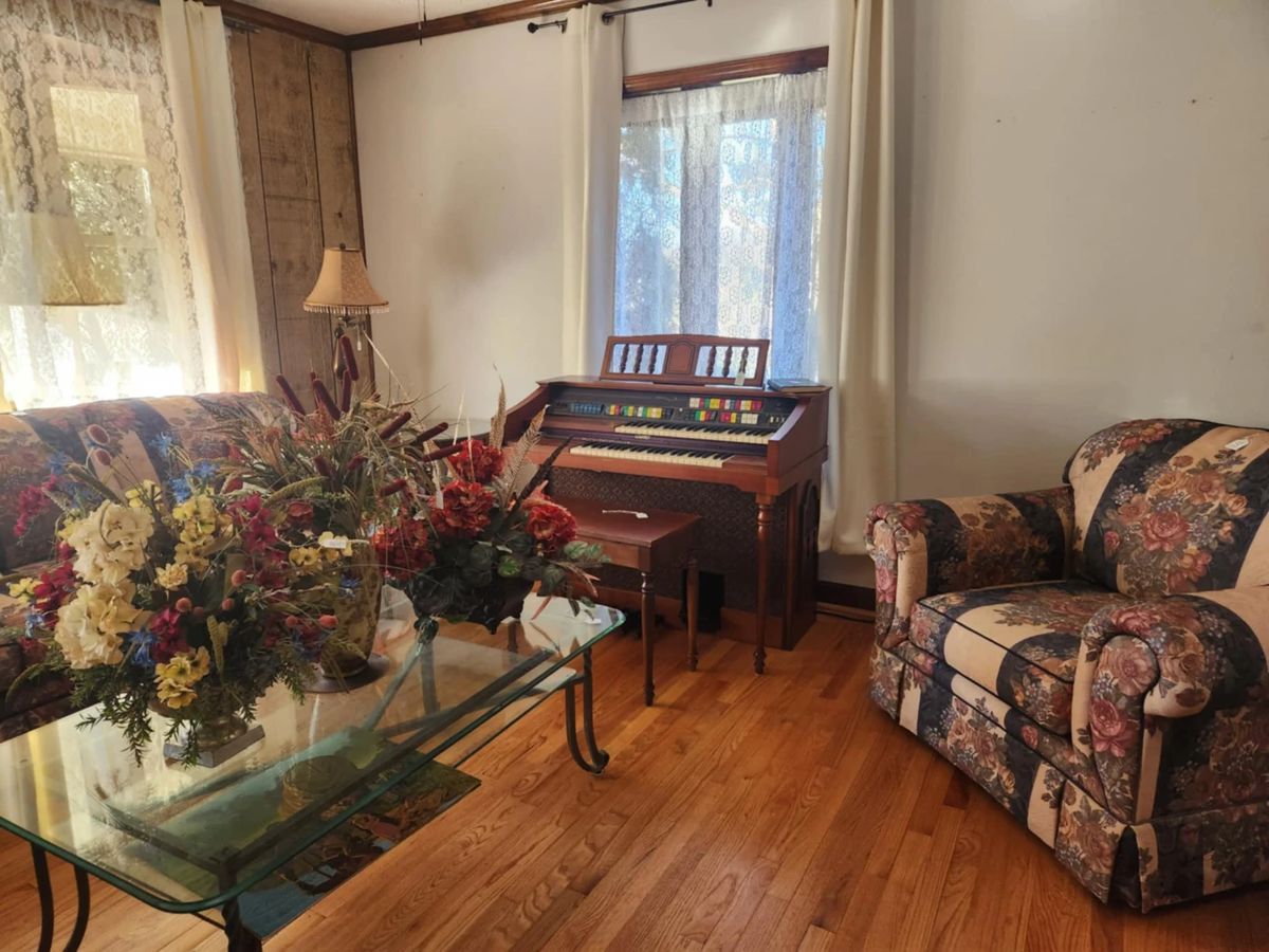 Beautiful living room furniture: sofa, chair, & loveseat, Lowrey organ, glass top coffee table, floral arrangements, lamps, vintage side tables,