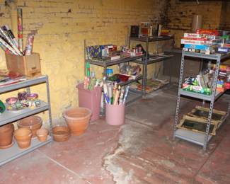 Variety of books, games, wrapping paper, clay pots, metal shelves.