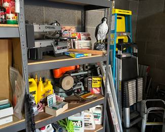 The shelving unit is filled with garden and wood working tools